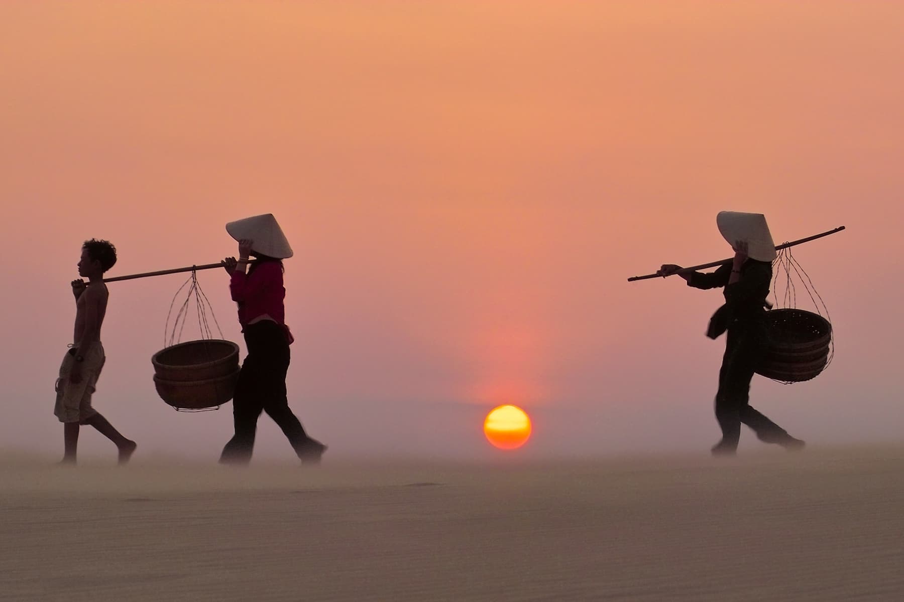 Asian locals at sunset in traditional hats