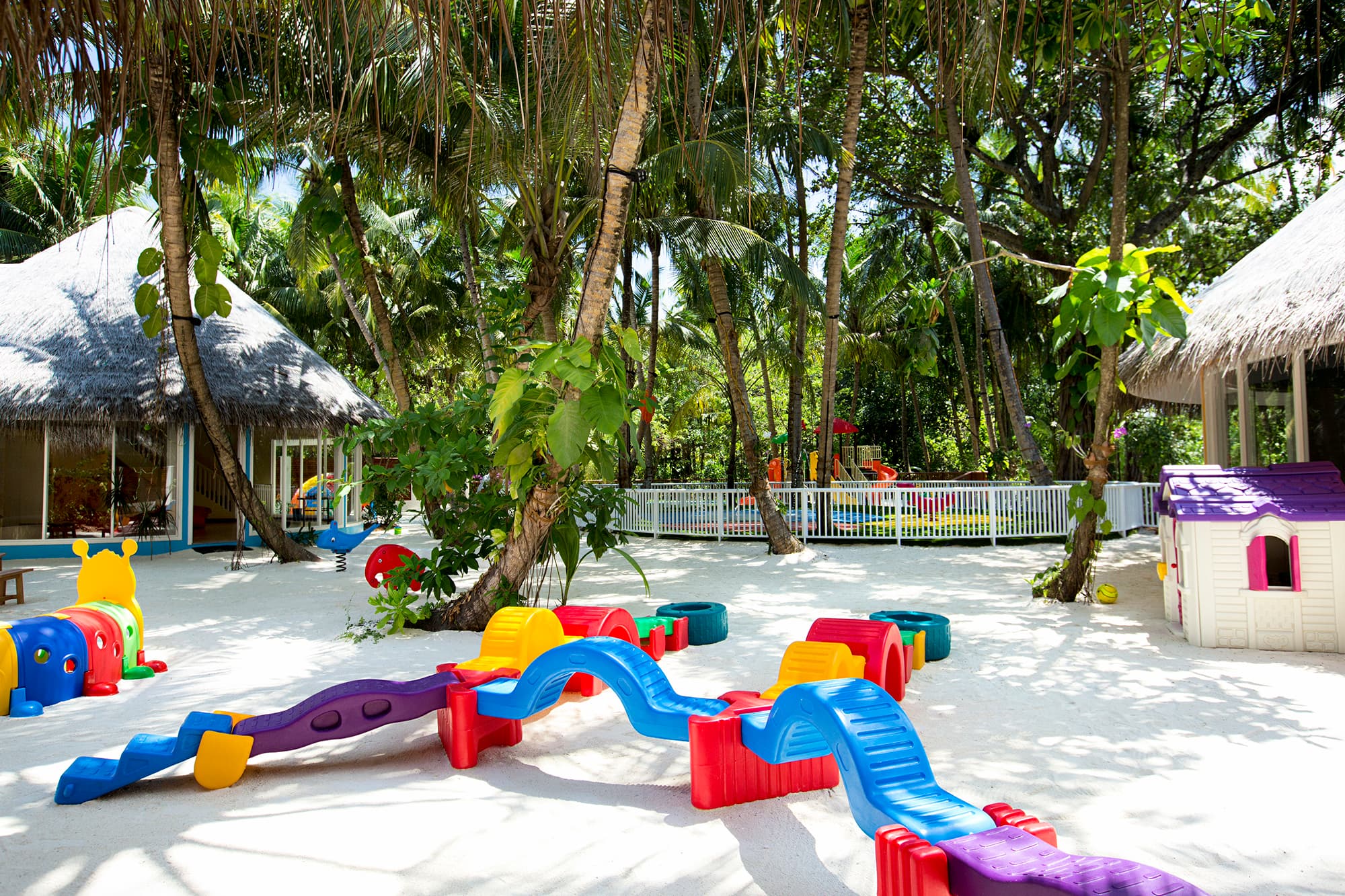 Kids' play equipment sits on the beach in the shade of palm trees at Niyama Private Island, the Maldives